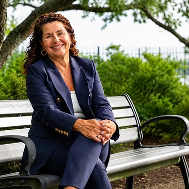 Deborah Gonzalez smiling while seated on an outdoor park bench
